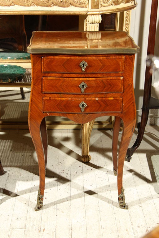 A  3 DRAWER SIDE TABLE IN MARQUETRY VENEERS, WITH BRONZE ESCUTCHEONS,  SABOTS, AND GALLERY EDGE, CABRIOLE LEGS