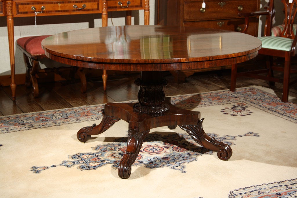 English, rosewood lune / center hall table on quad base with foliate carving to the legs and scroll feet. The foliate and scroll carvings at the base of the column are exquisite.