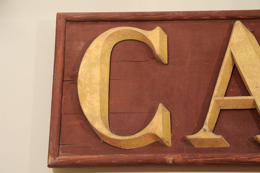 Metal letters attached to wooden frame.