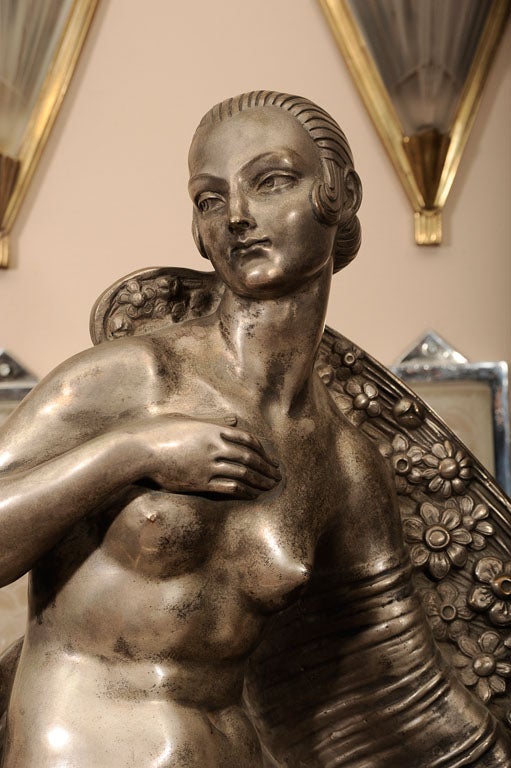 An Art Deco silvered bronze representing a nude, kneeling female figure, mounted on a granite base, from c. 1925 by Joe Descomps (French, 1869-1950). Signed in the mold, with foundry mark.