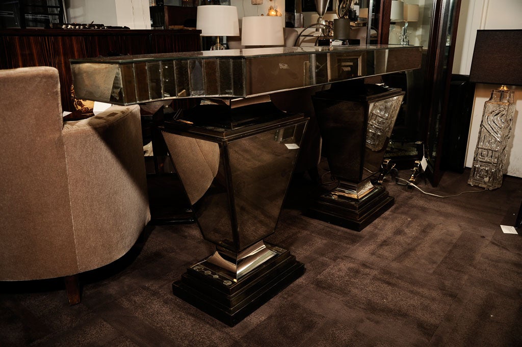 Designed by David Harriton, this<br />
spectacular console table was <br />
featured in the 1937 Paris Exposition.<br />
This console is made of smoked<br />
antiqued mirror with ebonized wood<br />
detailing.  The console top has<br />
a