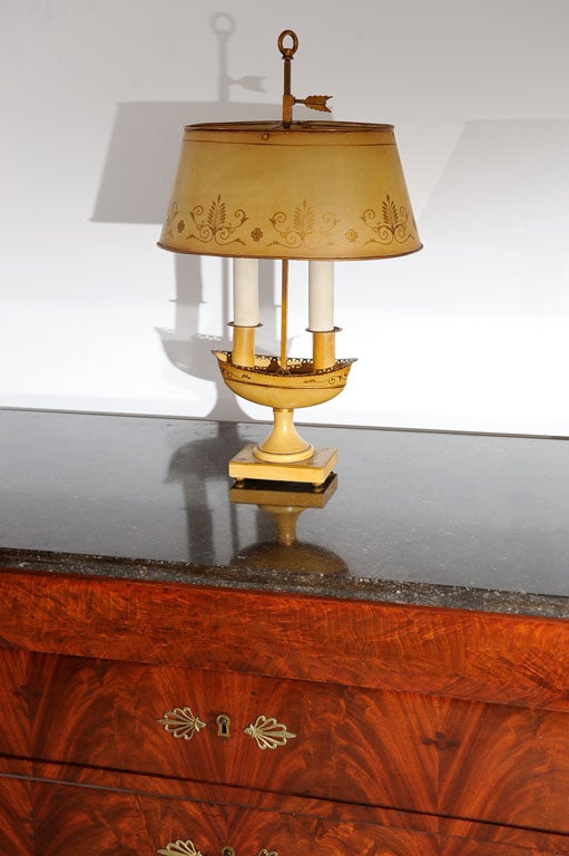 Two-light tole lamp.  Aged golden-tan paint color with applied gold design and accents.  Two lights rise from elongated bowl with gallery rail on pedestal on base.