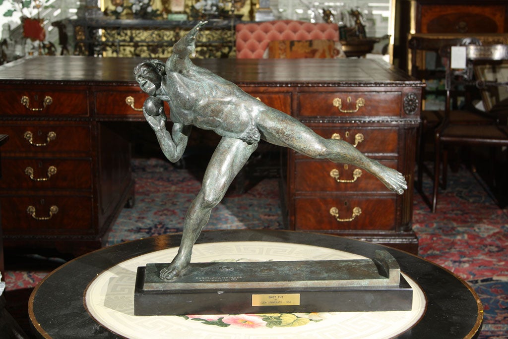 A bronze figure of a shot putter by New York artist Clem Spampinato (1912-1989).  This life-time casting is mounted on a Belgian marble base measuring 23.5 inches by 2 inches.  There is a modern New York Art Foundry mark on the base.