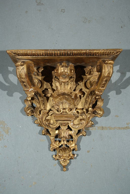 A carved and gilt wall bracket with shells, acanthus leaves and bell flowers.