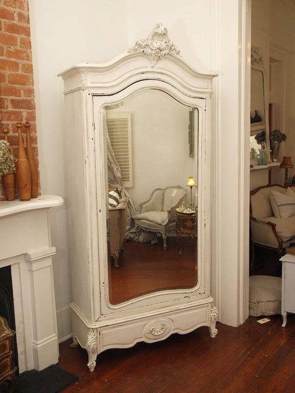 Gorgeous Antique French Armoire with Rose Crest Hand Carvings.  Painted inside and out in a Belgian white color. Original old beveled mirror door, great french carved legs. This armoire has a single drawer at the bottom.<br />
<br />
Very solid