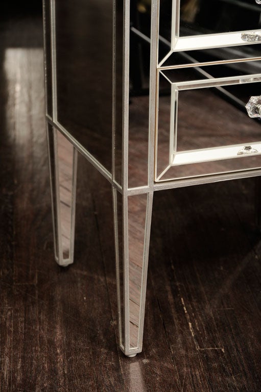 Pair of custom mirrored commodes with silver trim.