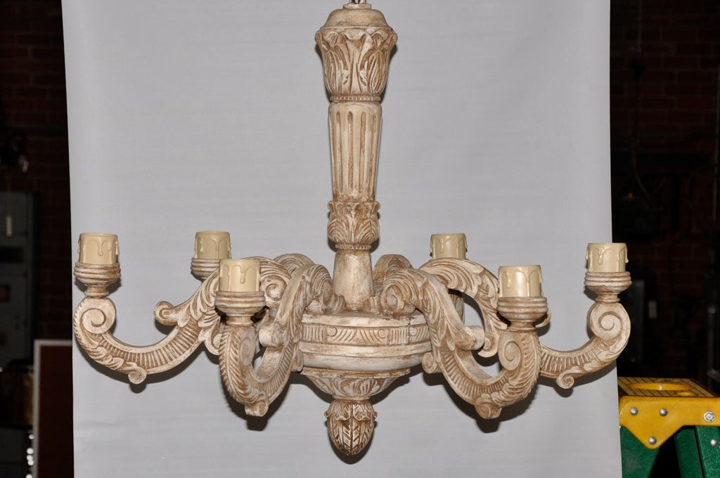 This continental carved wood chandelier, is probably French and from the 1920's. It has six up-lights and a white wash finish.