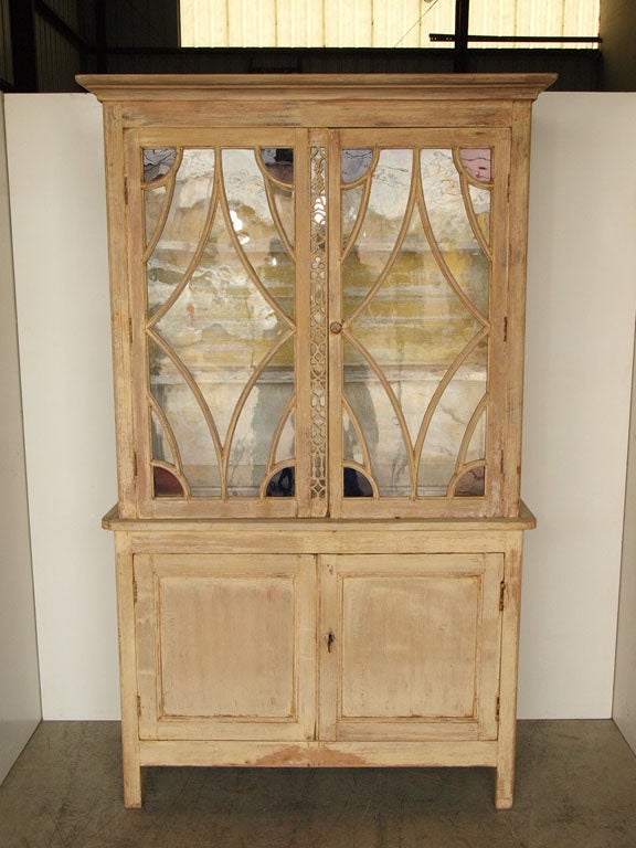 This pretty French Provencial painted pine Buffet Deux Corps features decorative glass front upper doors with blue and red stained glass accents. Lower and deeper locking cabinet also features two-door facade and one shelf on the left side. Key