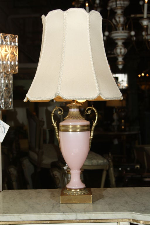 A pair of antique French pink urn-shaped Opaline lamps with bronze cast and handles, on square bases.