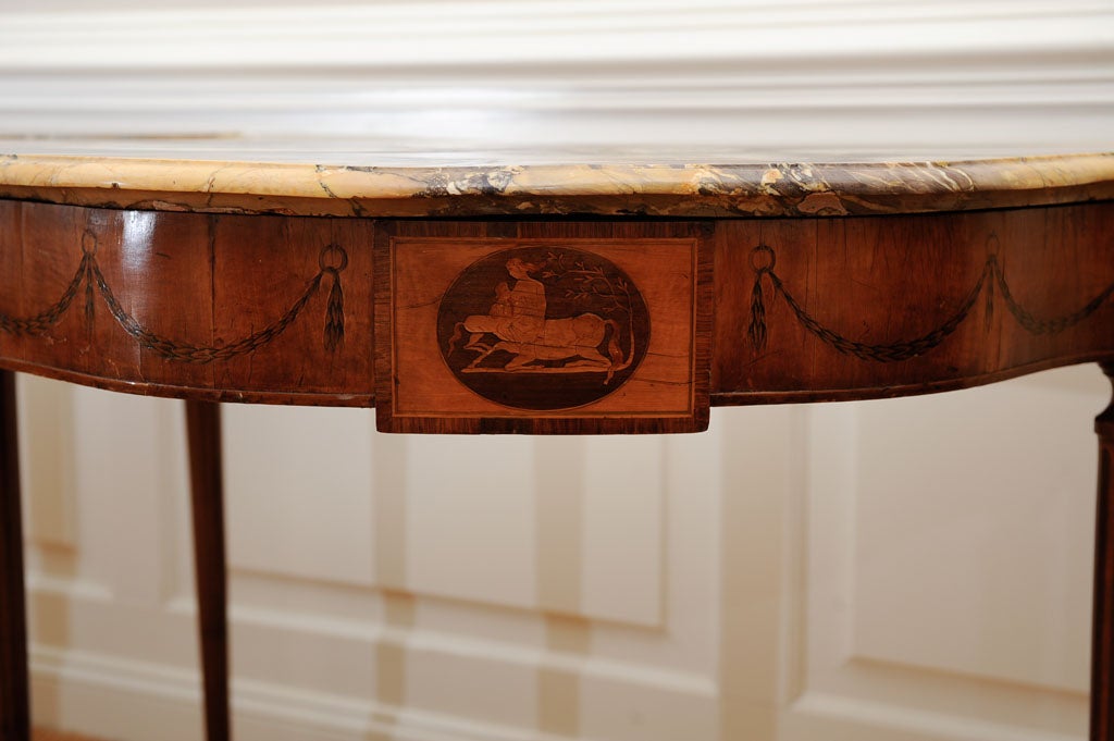Pair of Marquetry Fruitwood Sheraton Consoles in the manor of John McLean,(one copied) Apron with mother and child cameo(original facing left)flanked by swags of wheat. Four reeded inlay tapered legs with spool feet. Beige & Black mottled marble