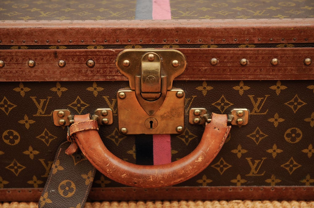 Vintage French Louis Vuitton leather and canvas suitcase with the reinforced brass corners and latch. The exterior with the LV monogram canvas with the leather trim stamped with the LV logo. The interior with buff colored canvas and cotton straps