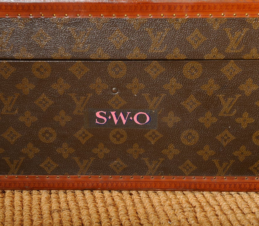 Vintage French Louis Vuitton leather and canvas suitcase with the reinforced brass corners and latch. The exterior with the LV monogram canvas with the leather trim stamped with the LV logo. The interior with buff colored canvas and cotton