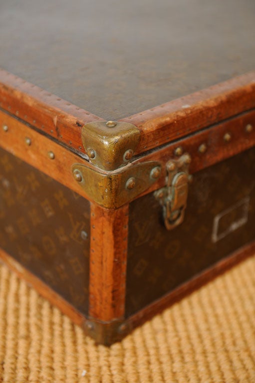 Vintage French Louis Vuitton leather and canvas suitcase with the reinforced brass corners and latch. The exterior with the LV monogram canvas with the leather trim stamped with the LV logo. The interior with buff colored canvas and cotton straps