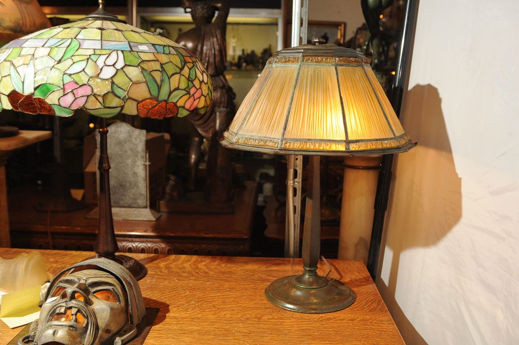 One of Tiffany's more unique table lamps is their linenfold model.  This example is a fine choice for any collector or setting.  It is properly signed and gives very warm, soft light.  The glass heat cap keeps in step with the overall beauty of the