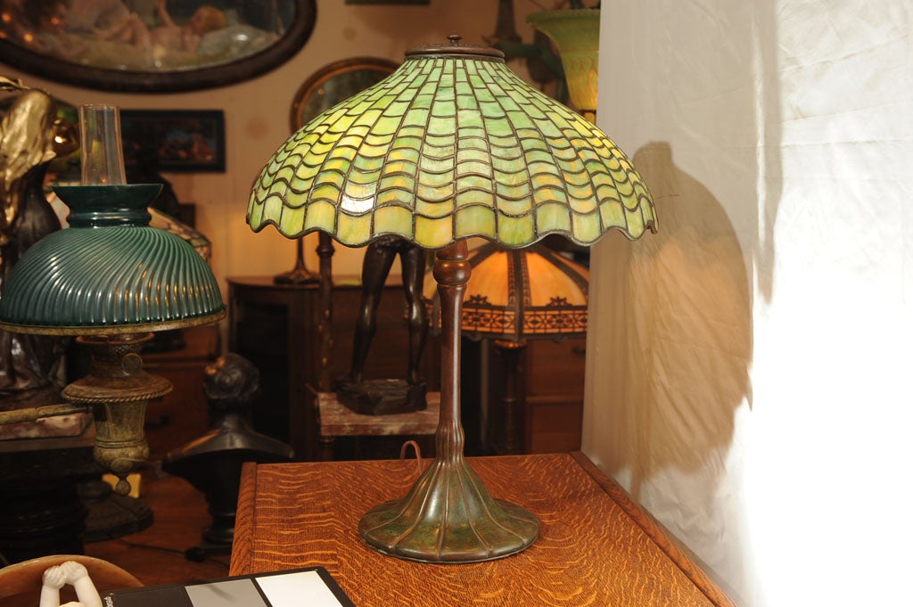 A rather unusual Tiffany geometric table lamp.  Very few Tiffany lamps have irregular borders, especially geometrics.  Here is a chance to own one.  Nicely mottled Tiffany green glass in the shade; NOT a later example with commercial glass.  This
