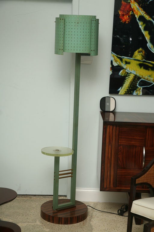 The pierced metal shade above a square rod, the rod turning upward to create a glass tabletop, on an ebony de Macassar base.