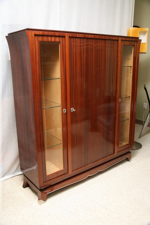 Very unique dry bar in the highest quality mahogany with accents of citroniere.  The inside is sycamore.  This high bar has a center door that opens in a circular fashion to have  a 180 degree bar on the back of the door.  It has a lower shelf with