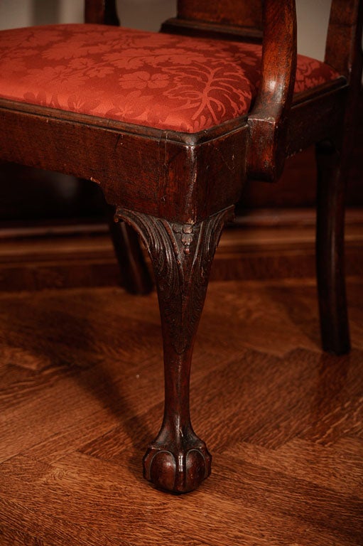 This impressive set of seven Chippendale chairs date from the mid-18th century and incorporate designs used by several known Philadelphia cabinetmakers, such as the richly carved acanthus and floral knees and scrolled cabriole legs.  In particular,