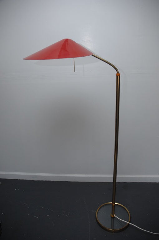 Italian adjustable floor lamp by Fontana Arte.

Enameled metal shade attached to a brass arm and pole standing on a glass base. Restored and rewired.
