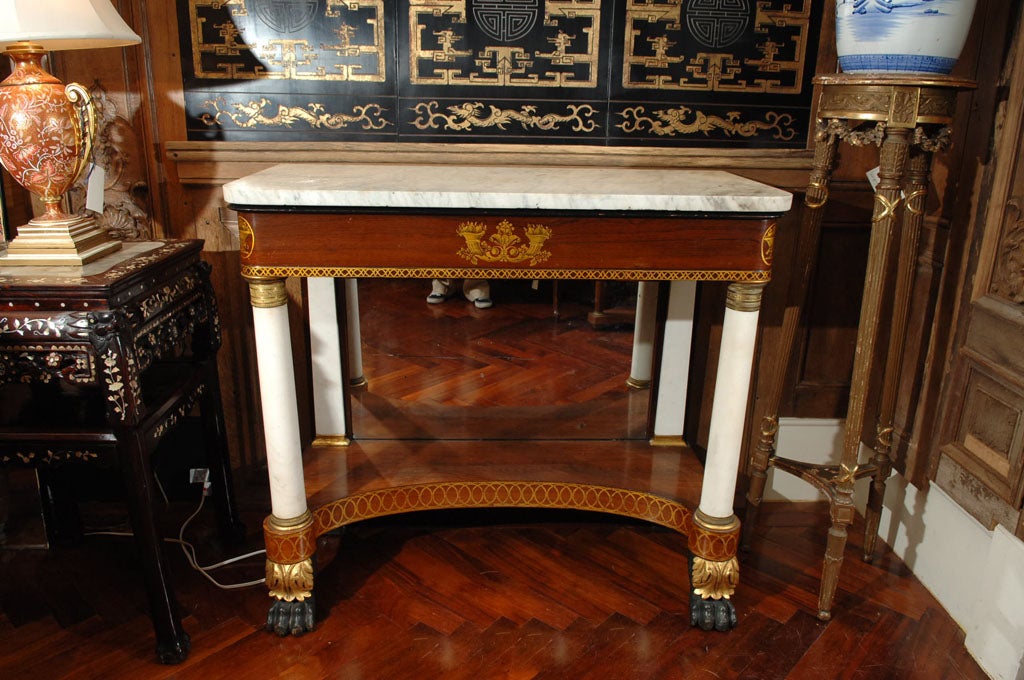 American mahogany, paint, parcel gilt and gilt stenciled console talbe with marble columns having gilt bronze capitals, marble pilasters, and marble top, with<br />
mirrored back panel, New York in the manner of Lannuier, circa 1820.