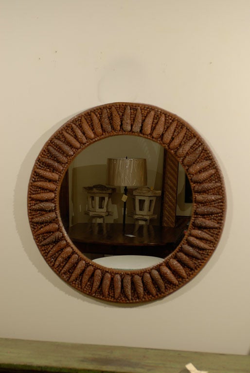 This is a fabulous round mirror.  The custom frame is hand made with real pine cones.  The details are hard to miss.  This custom frame was made by Fred Reed Picture Framing.<br />
<br />
Please visit our website for more pieces.<br