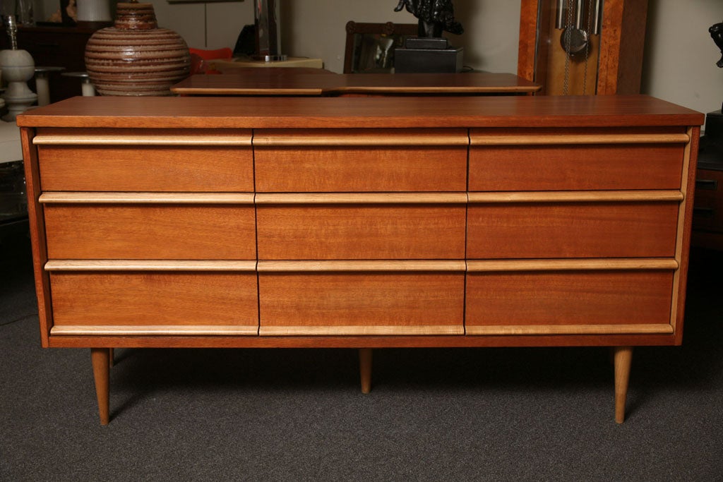 ..SOLD MAY 2010...With two-toned walnut styling, this smart nine drawer dresser not only delivers superior mid century looks but plenty of storage space as well.  Freshly restored, it features bleached walnut carved drawer pulls and tapered legs in