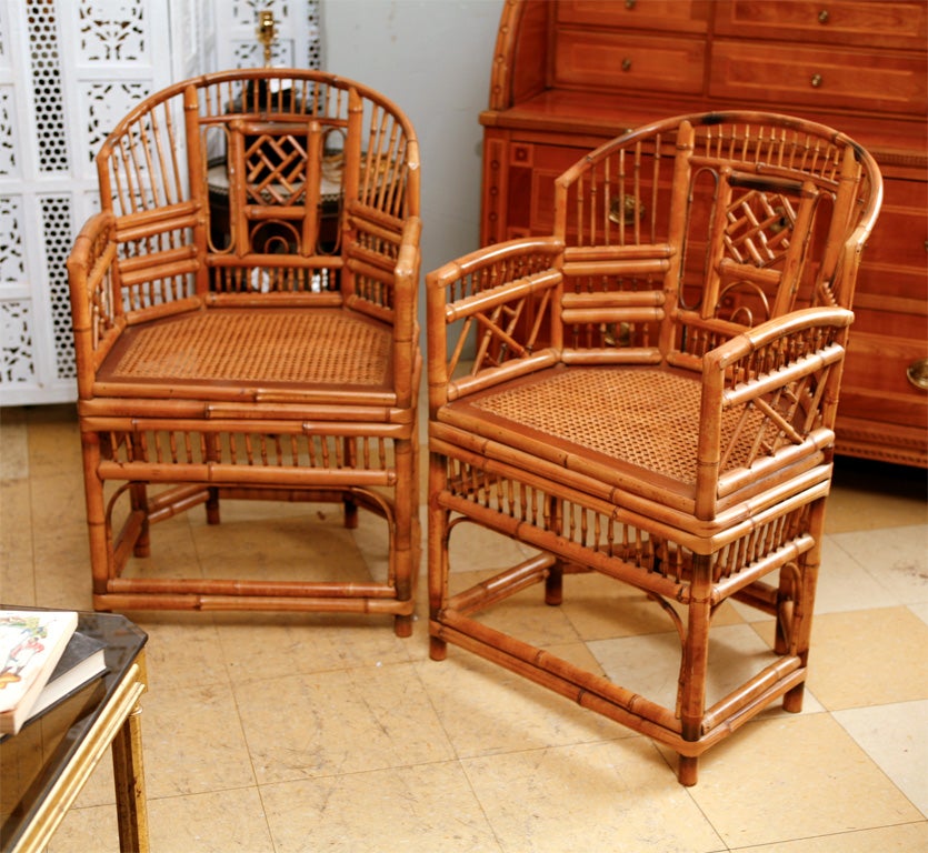 Very stylish vintage plantation style bamboo arm chairs.   Each with a curved toprail and open back centered with a fretwork backrest, caned seats with banded apron, the legs are joined by stretchers.  <br />
<br />
Keywords:  tortoise or bamboo