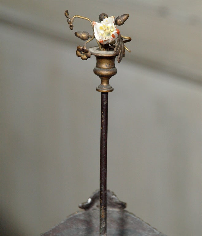 A black tole container with hand painted flower garlands.  Each side has a cartouche depicting  a profile in a gold oval.  A painted garland anchored by a medallion edge the top of the oval container.  Under the side handles, a floral garland stream