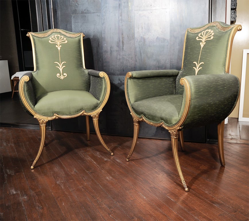 A pair of wonderfully-proportioned French armchairs in their original raw silk upholstery with a signature Art Nouveau motif at backrest. Featuring scrolled and fluted frames with gently curved sides and ultra-slender sabre legs at the front, this