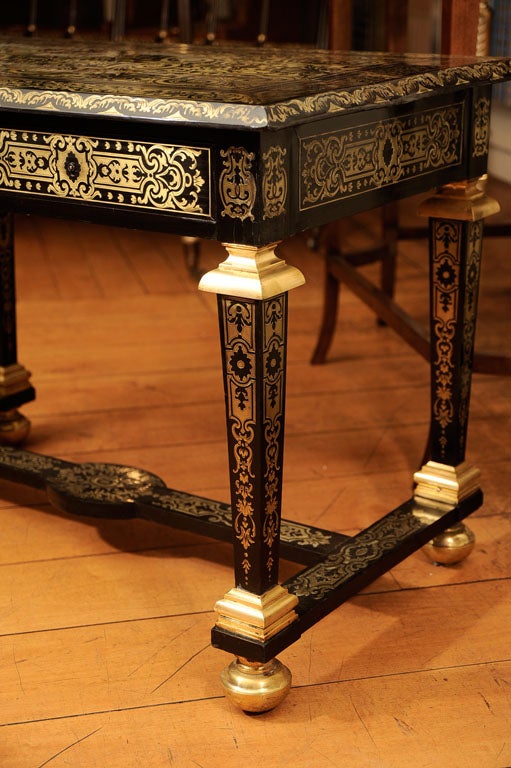 The rectangular top inlaid with pierced foliate brass work, all raised on brass mounted square tapering similarly inlaid legs ending in a stretcher and brass bun feet.