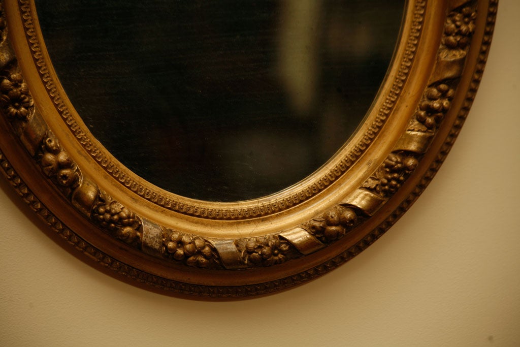 Oval gilt wood frame mirror. Italian 19th Century