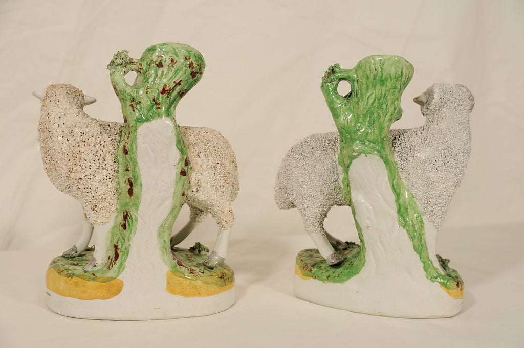 A lovely pair of Staffordshire sheep (ram and ewe) their rough coats formed by tiny pieces of pottery. The tree behind them forms a spill vase which was a popular form in the 18th and 19th century