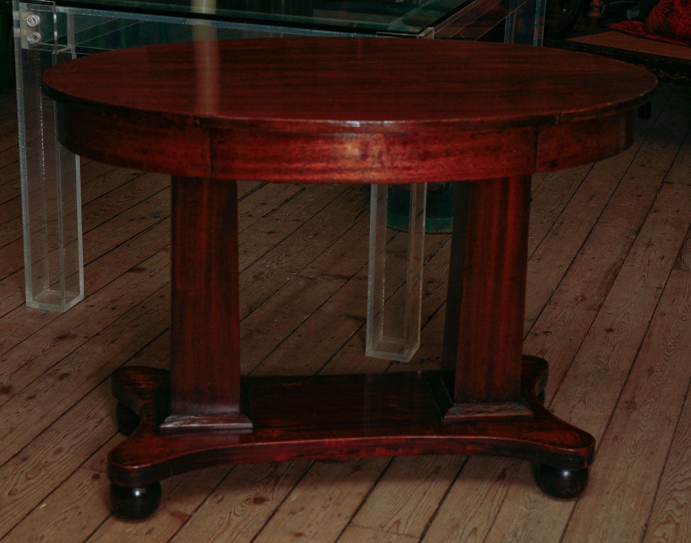 Pillar and scroll mahogany Empire table with single drawer.
