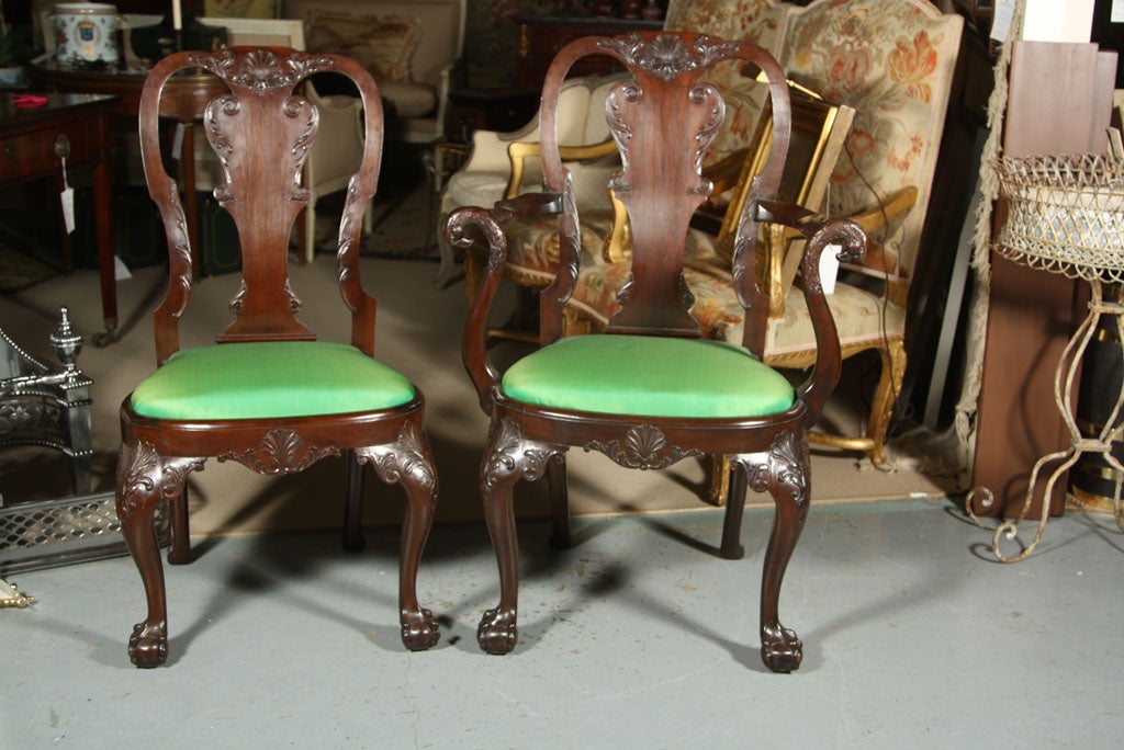 A set of eight Irish Georgian style mahogany dining chairs consisting of two arms and four sides having ballaster form splat back ending on ball and claw feet with newly upholsterd drop in seats.  <br />
<br />
Armchairs measure 41.5h x 28w x 22.5d