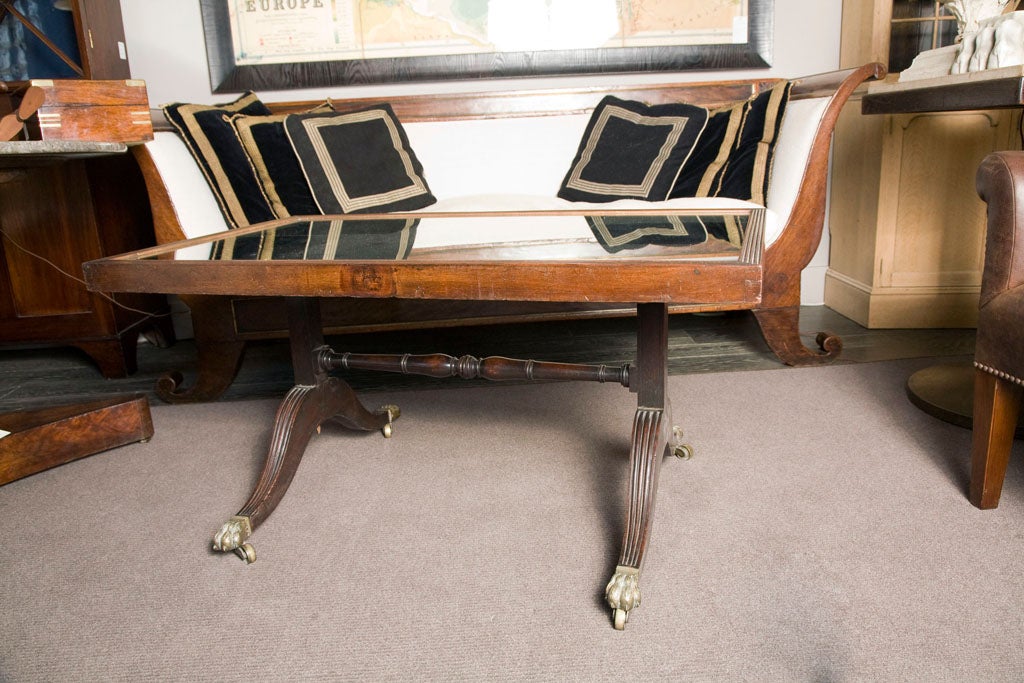 A beautiful mirrored and reeded top coffee table in mahogany with splayed legs and brass paw feet with castors.