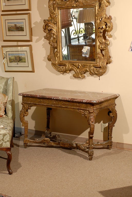 A Fine Louis XIV Period Giltwood Console Table with Rouge Royale Marble Top and Cross Stretcher, dating from the first quarter of the 18th century and French in origin.