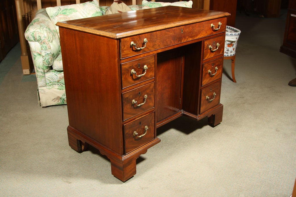 An excellent example of its form, this English mahogany kneehole desk is proportioned nicely for use in a bedroom or small study. Designed as a work space and to hold pens and ink as well as various personal effects and documents (in the large