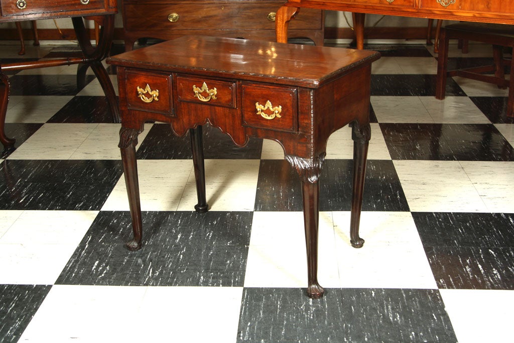 A fine example of the form, this Irish mahogany lowboy features delicate carving on the top edge, knees and feet. Classic details such as the edge beading and acanthus carved knees abound in this unique little table.