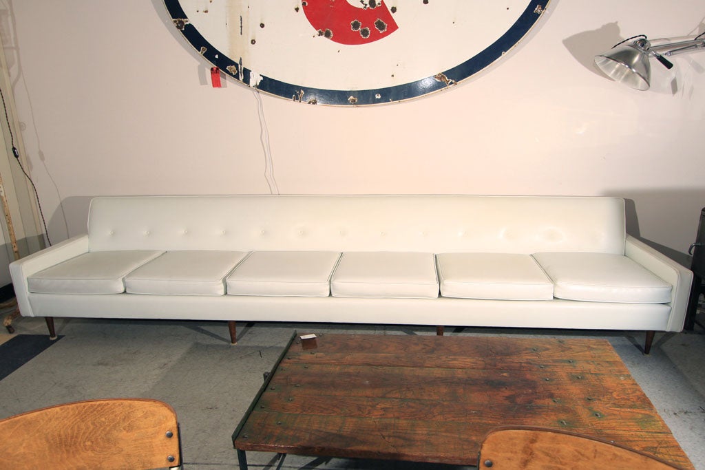 Fantastic, almost 12' long! Sleek, white vinyl sofa with wood feet.