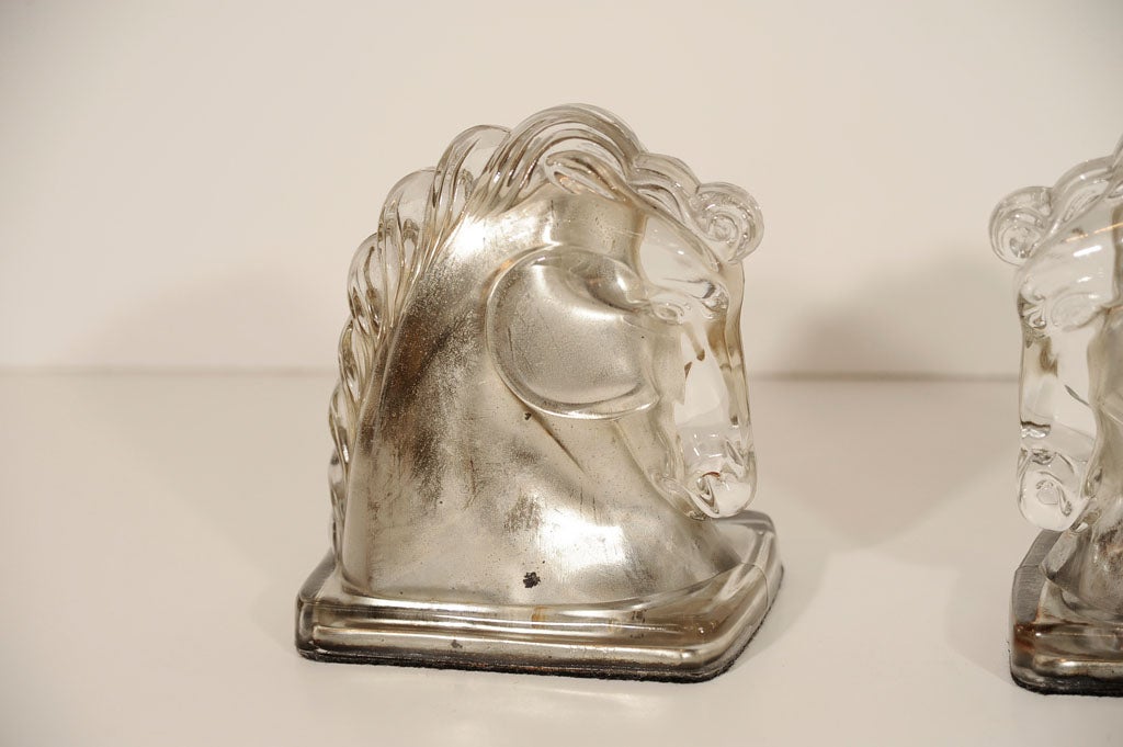 These beautiful book ends are made <br />
of molded glass with reverse painted<br />
antique silver leaf.  Highly stylized<br />
horse head profile and mane.