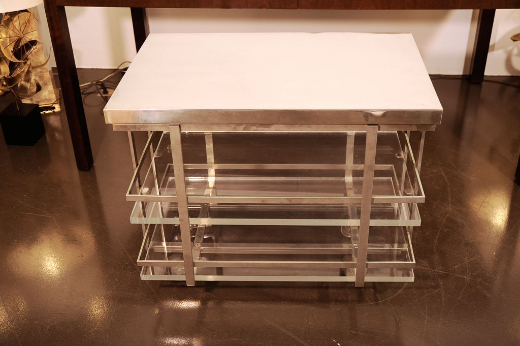 Bar cart with two Lucite shelves and polished chrome top <br />
with four wheels and swiveling top.