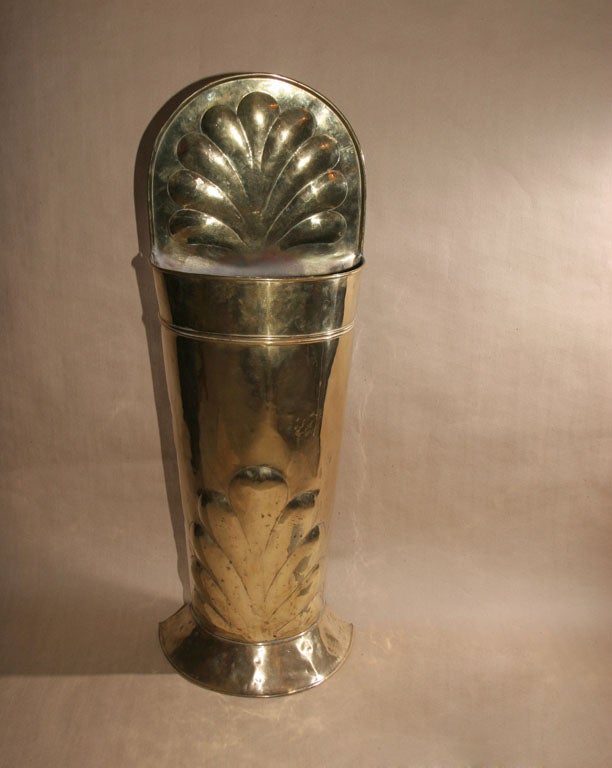 Dutch brass umbrella holder, the shaped top with crimped edge and embossed stylized anthemion over half round pocket standing on flared base, the former with stylized embossed waterleaf.