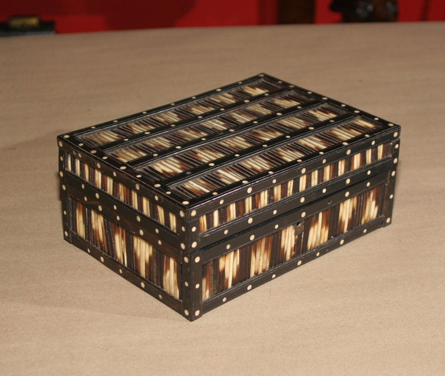 Anglo-Indian box made of split porcupine quill, ebony and ivory, the interior with ivory inlay and red lacquer ground.