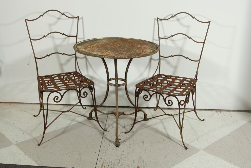 Offered here is an antique or very vintage classic French Bistro set (Table and two chairs).  Excellent Design - Table has rust and so do the chairs.  Table is 27.5