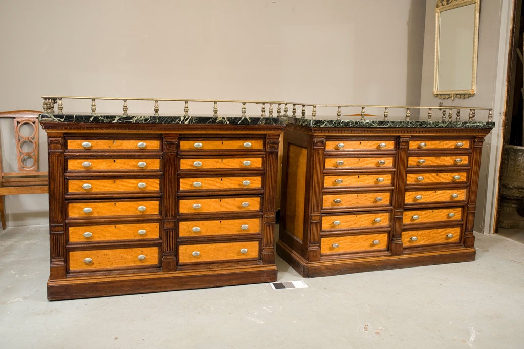 Pr. of matching map chests by the firm Gillows in satinwood and mahogany. Original green marble tops with silver plated bronze gallery. Each lock is stamped and the piece itself is stamped 
