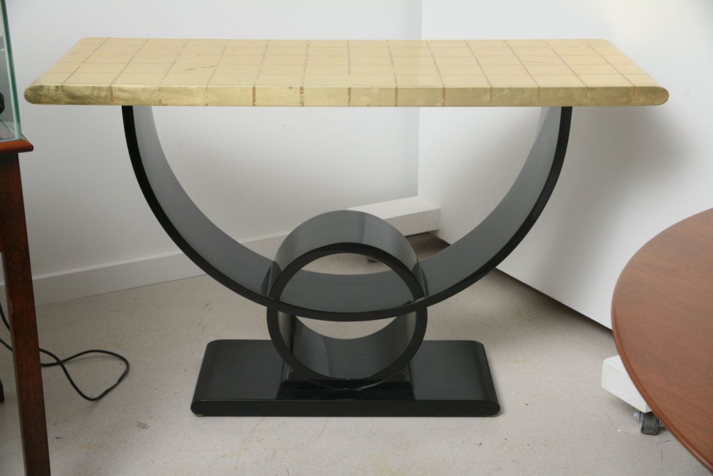 Deco style console table by Jay Spectre with black geometric base and gold leaf top with repetitive square motif.