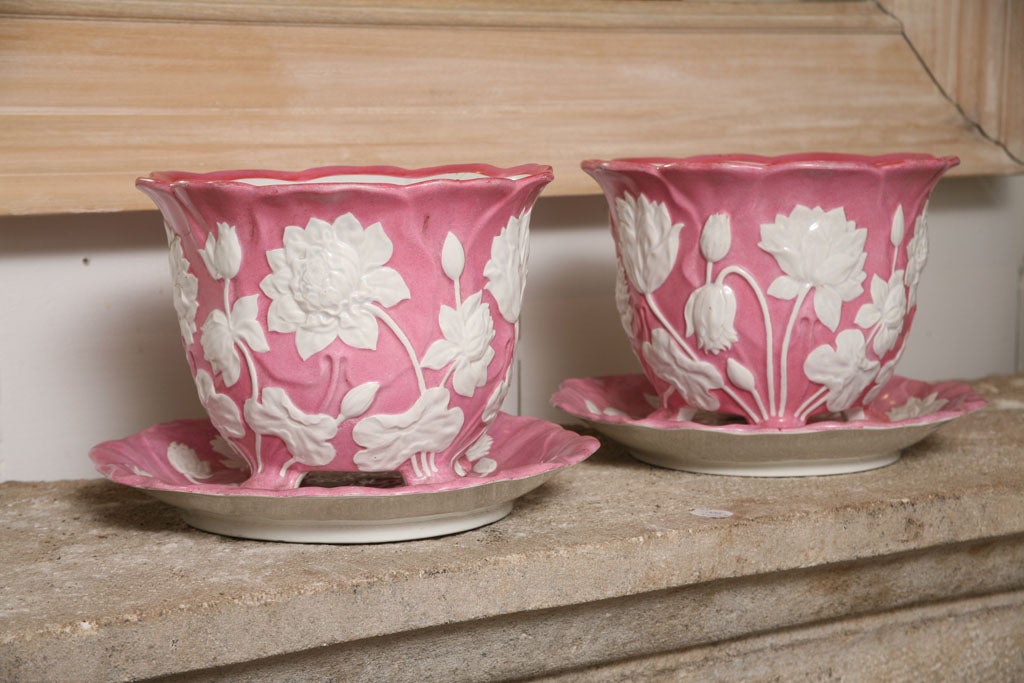 Cast, footed pink planters with a raised motif of white flowers. Separate drip plate 11 1/4 wide. Marked Creil et Montereau