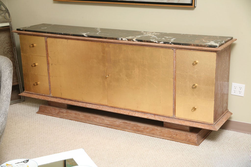 This piece is a perfect example of the modernism direction of the 1940's. Solid oak with a marble top.   Two doors open to large one shelf space. Each side with three drawers. Very elegant and contemporary design.