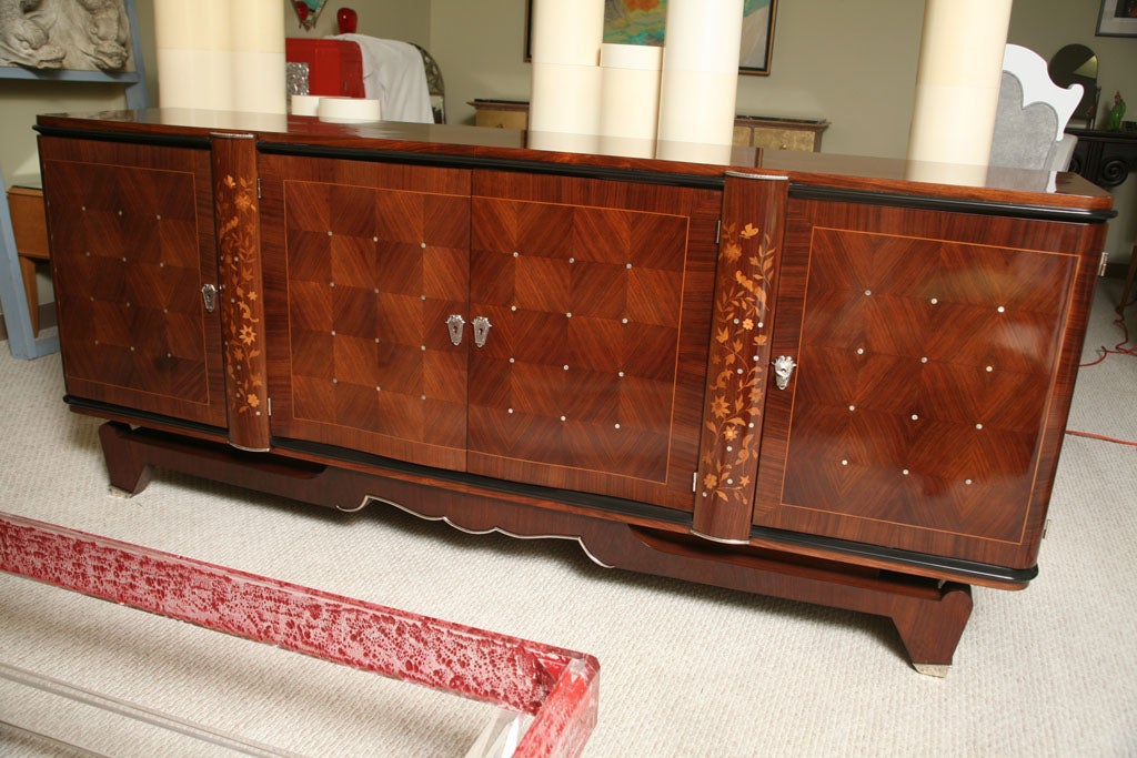 Very refined rosewood and mahogany sideboard with four doors opening in the front. Lozenge patterned and inlayed with mother of pearl.Two half vertical columns inlaid with decorative flowers ,birds and butterflies in lemontree wood  ., sycamore,