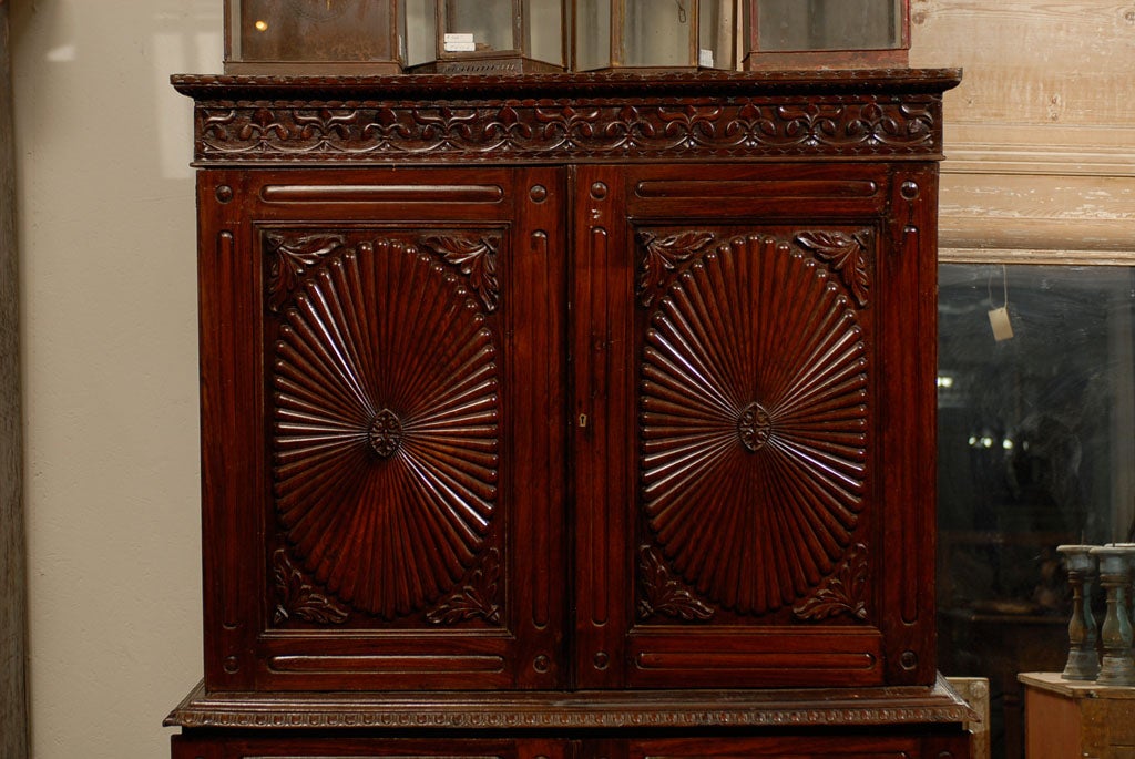 A 19th Century Brown British Colonial Cabinet, Ornately Carved with Oval Patterns and Floral Molding.